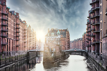 old warehouses on both sides of canal in the Speicherstadt district in Hamburg, Germany on sunny day