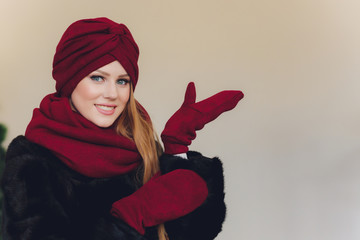 Photo of self assured Arabian lady in hijab, shows you right way, points at blank space with both...