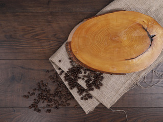 Wood board and coffee beans on tablecloth. 