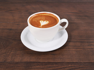 Cup of coffee on the wood table with latte art