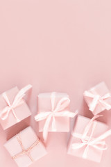 Christmas pink flat lay. Holiday boxes, fir branches on pink background. Christmas winter holiday congratulation invitation birthday wedding