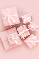 Christmas pink flat lay. Holiday boxes, fir branches on pink background. Christmas winter holiday congratulation invitation birthday wedding