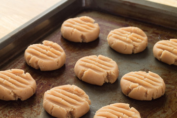 Peanut butter cookies ready for oven on rustic baking sheet