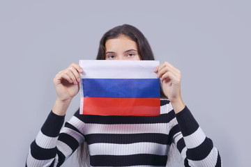 girl holding in hands russian flag and closing part of face