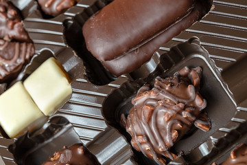 Appetizing food background. Assorted handmade candy in the box close up. Chocolate background. 