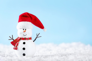 Snowman on snow over blue paper background. Winter holidays