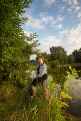 Russian lady sits on the background of the lake
