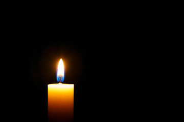 Burning candle on black background,space for text