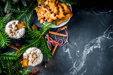 Christmas gingerbread hot chocolate with homemade gingerbread cookies and winter spices, with Christmas decoration and fir tree, copy space