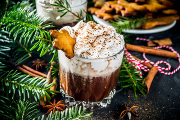 Christmas gingerbread hot chocolate with homemade gingerbread cookies and winter spices, with Christmas decoration and fir tree, copy space