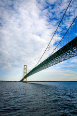 The Mackinac bridge extends to the horizon above the waters of Lake Huron and Lake Michigan.