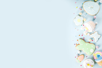 Easter holiday greeting card background. Cute homemade cupcakes with traditional Easter bunny, egg and springtime flowers decor. Happy easter concept. Copy space for your text