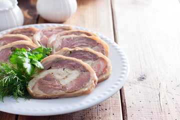 Cooked pork knuckle roll with chicken on a white plate, horizontal, copy space