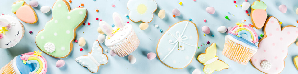 Easter holiday greeting card background. Cute homemade cupcakes with traditional Easter bunny, egg and springtime flowers decor. Happy easter concept. Copy space for your text