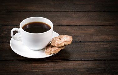 cup of coffee with cookies on a wooden background