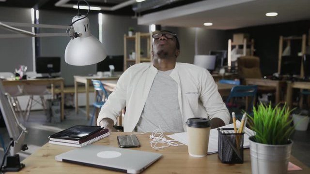 Tired African business man is closing notebook and lean back