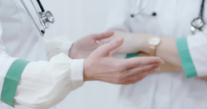 Two Female doctor torso with stethoscope, hands gesturing, explaining, discussing. Ready to receive patient and help. Medical concept.