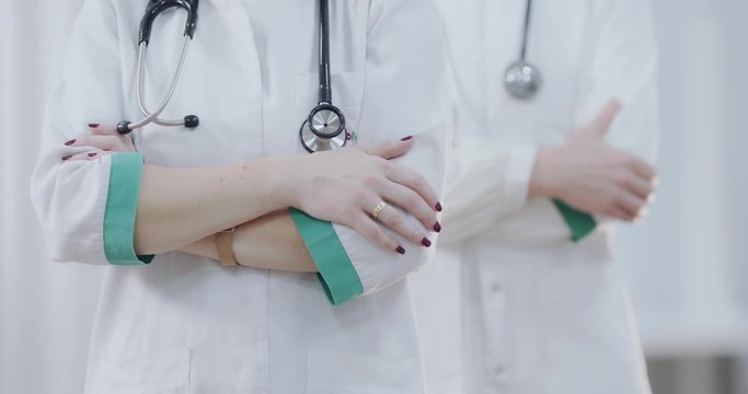 Two Female doctor with stethoscope, hands crossed. Ready to receive patient and help. Medical concept.