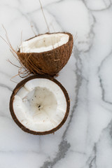 fresh cracked coconut on white marble background copy space