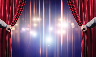 Bokeh lights behind drapery curtain and hand opening it