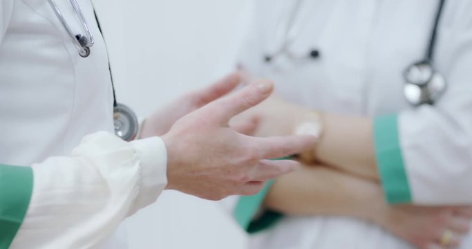 Two Female doctor torso with stethoscope, hands gesturing, explaining, discussing. Ready to receive patient and help. Medical concept.