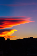 Amazing sunset with orange, pink and red stratus clouds over the city. Background for forecast and meteorology concept. Barcelona, Spain.