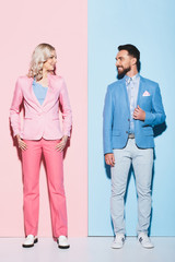 smiling woman and handsome man looking at each other on pink and blue background © LIGHTFIELD STUDIOS