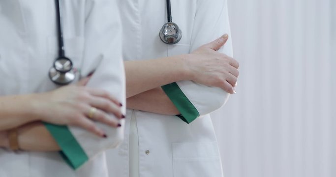 Two female doctor with stethoscope, hands crossed. Ready to receive patient and help. Medical concept.