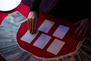 Hands of Beautiful young Asian woman Gypsy Fortune teller glowing crystal ball, tarot cards and...