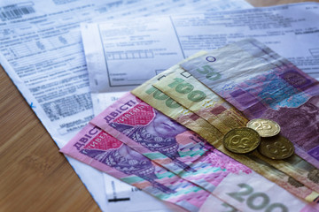 Ukrainian money hryvnia and coins penny wooden background, utility bill.