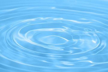 Closeup Water drop falling on the surface of the water and beautiful circular wave ripple, fresh natural mineral water drink water concept