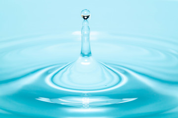 Closeup Water drop falling on the surface of the water and beautiful circular wave ripple, fresh natural mineral water drink water concept