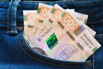 Obraz premium Ukrainian money. New banknotes five hundred hryvnia bills UAH in the back pocket of blue jeans. Money concept, Corruption.