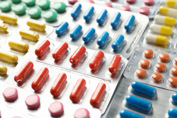 Pills in blister packs textured background, close up