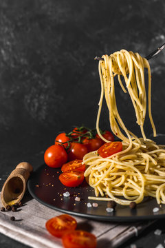  fragrant Italian spaghetti pasta with tomato sauce and cheese and healthy spices served on a dark background