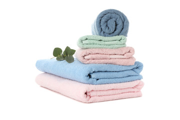 Fototapeta na wymiar Stack of colored towels and eucalyptus isolated on white background