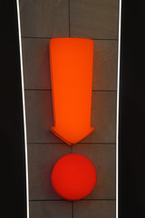 Orange exclamation mark calling attention. A sign located on a wall of carrot, red.