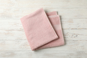 Obraz na płótnie Canvas Pink towel on white wooden background, top view