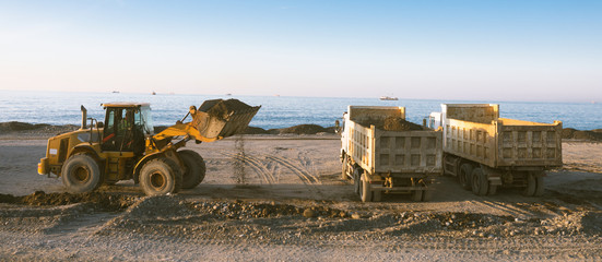 Excavator loads the excavation onto a truck (hydraulic)are heavy construction equipment consisting...
