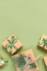 Christmas zero waste, eco friendly packaging. Festive Christmas composition packs gifts in kraft paper on a green background, eco Winter weekend concept, eco decor