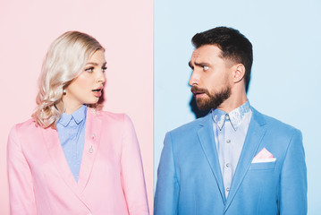 shocked woman and handsome man looking at each other on pink and blue background