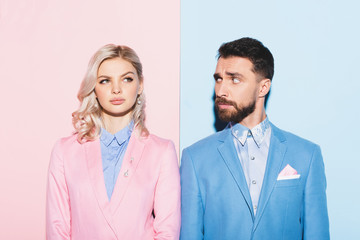 dreamy woman and handsome man looking at her on pink and blue background