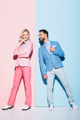 dreamy woman and handsome man looking at her on pink and blue background