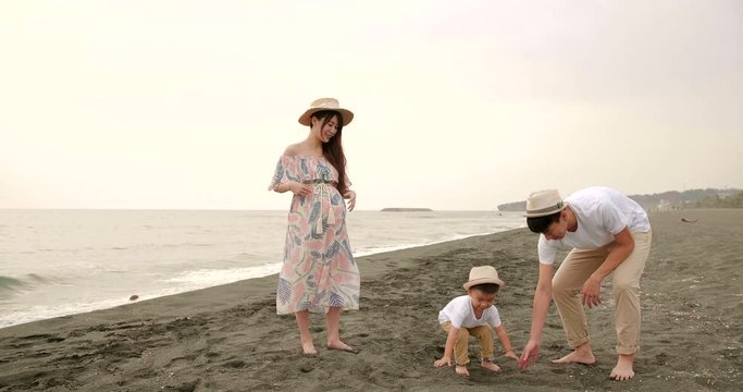 happy asian family having fun on the beach