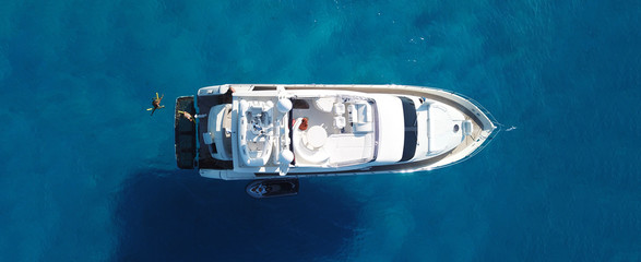 Aerial drone top down ultra wide photo of small yacht docked in tropical exotic turquoise sea
