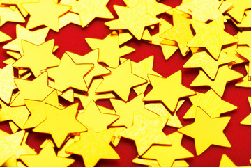 A scattering of Golden stars on red background. The concept of greeting cards, headlines and web site.