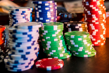 game and entertainment concept - many different casino chips on play table surface.  close up.