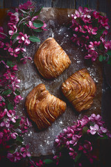 food flatlay on table with several brown buns and flowers