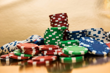 Stacks of poker chips isolated on golden background. Casino