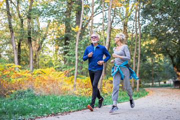 Mature couple man and woman jogging in the park